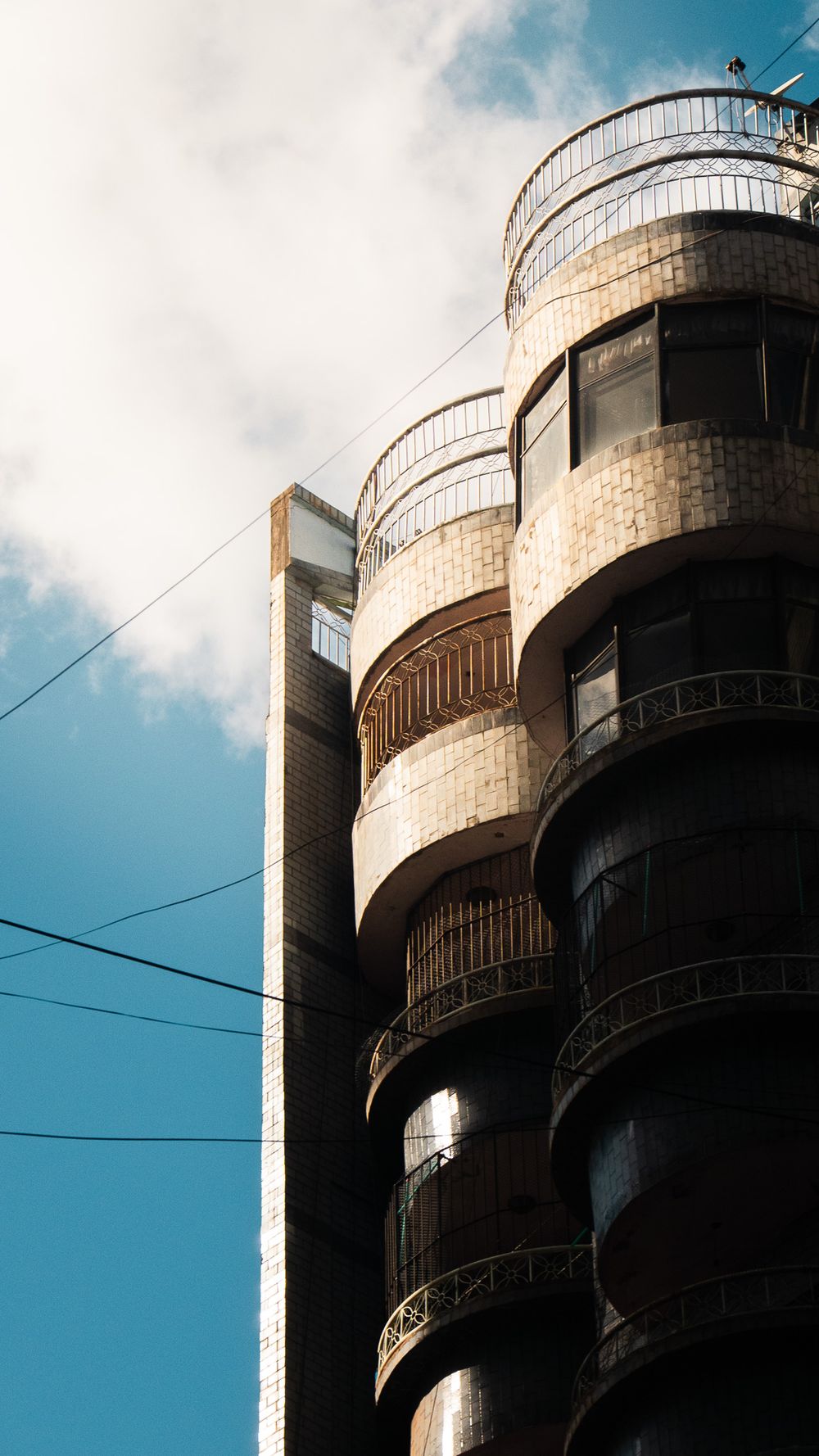 Fachada de un edificio con balcones curvos escalonados contra un cielo celeste