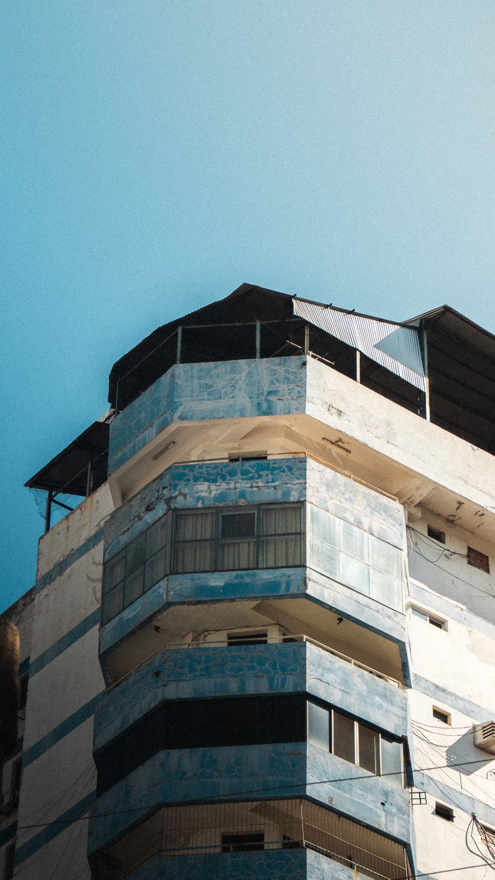 Fachada de un edificio con balcones curvos pintados de azul y blanco, en Ciudad del Este
