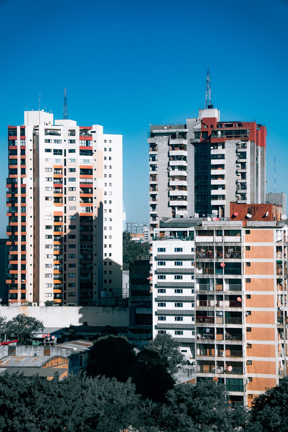 Dos torres de departamentos de Ciudad del Este contra un cielo azul profundo